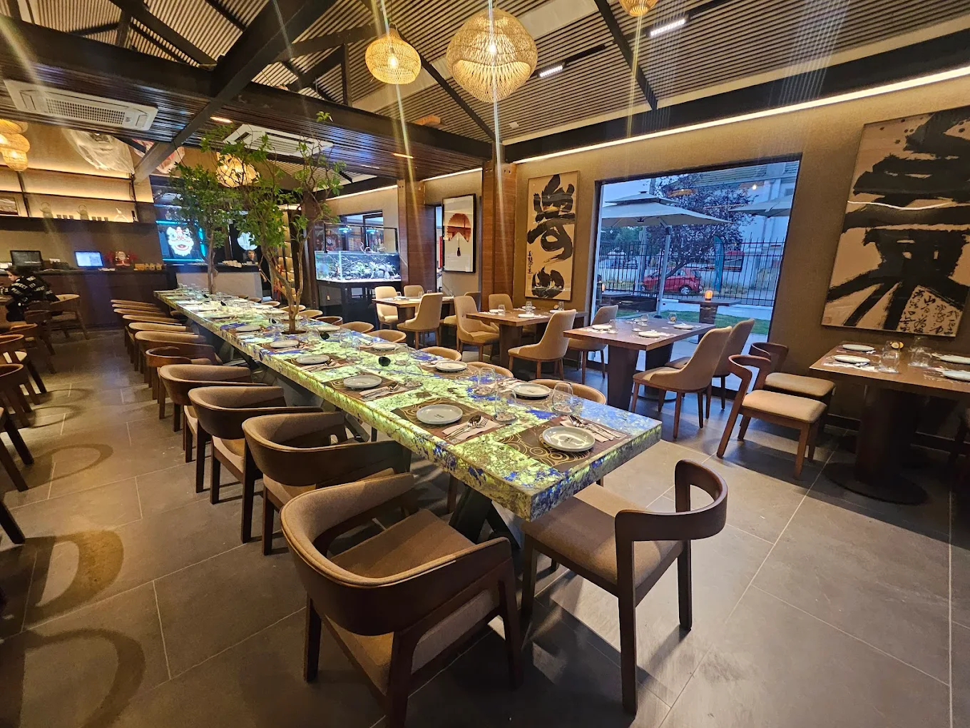 Mesa con un banquete chino: pato Pekín glaseado, dim sum en vaporeras de bambú y vegetales salteados, iluminados con luz cálida sobre una mesa de piedra oscura.
