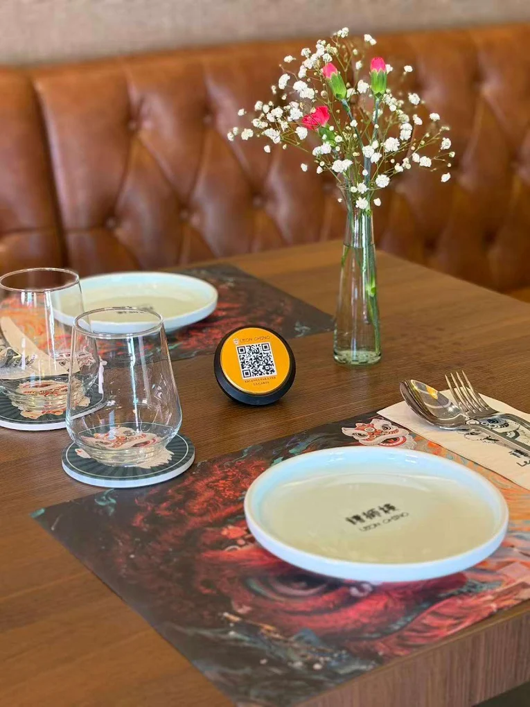 Mesa puesta en el restaurante Leon Chino con mantelería blanca y detalles cálidos.